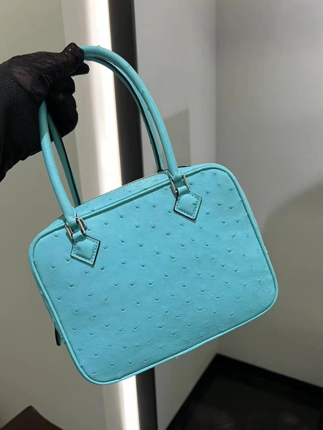 Womenās genuine ostrich skin leather handbag with top handle by Rossie Viren, showcasing smooth, textured leather and elegant design.
